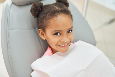 Young girl smiling in a dental chair
