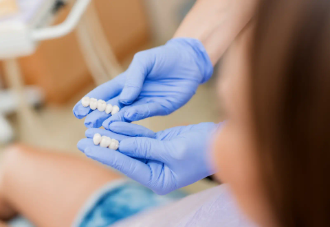 Dental bridge held in gloved hands